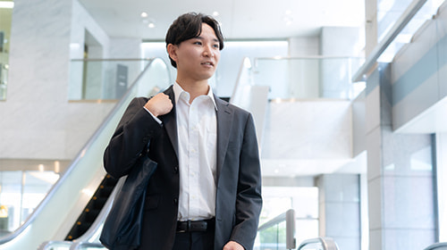 写真 屋内を歩くスーツの男性