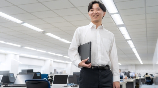 写真　屋内を歩くスーツの男性