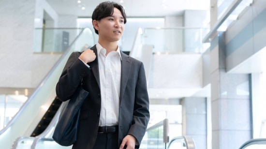 写真　パソコンの前で相談するスーツの男女